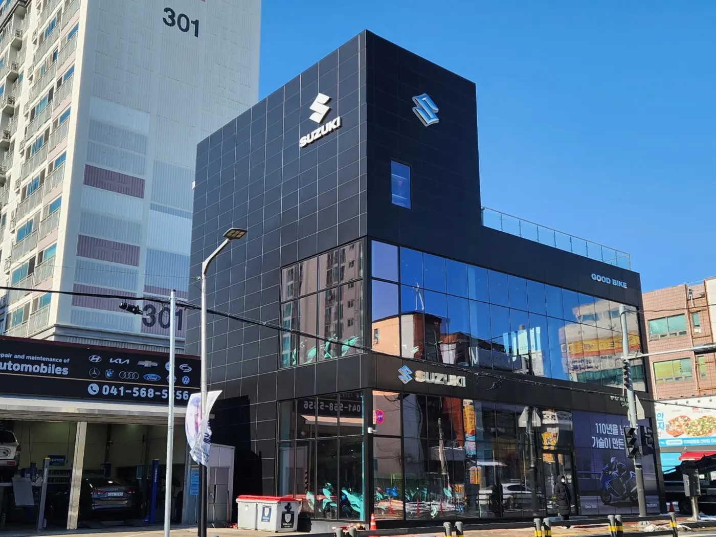 건물 벽면에 돌출간판을 브라켓으로 고정 설치하는 시공 현장